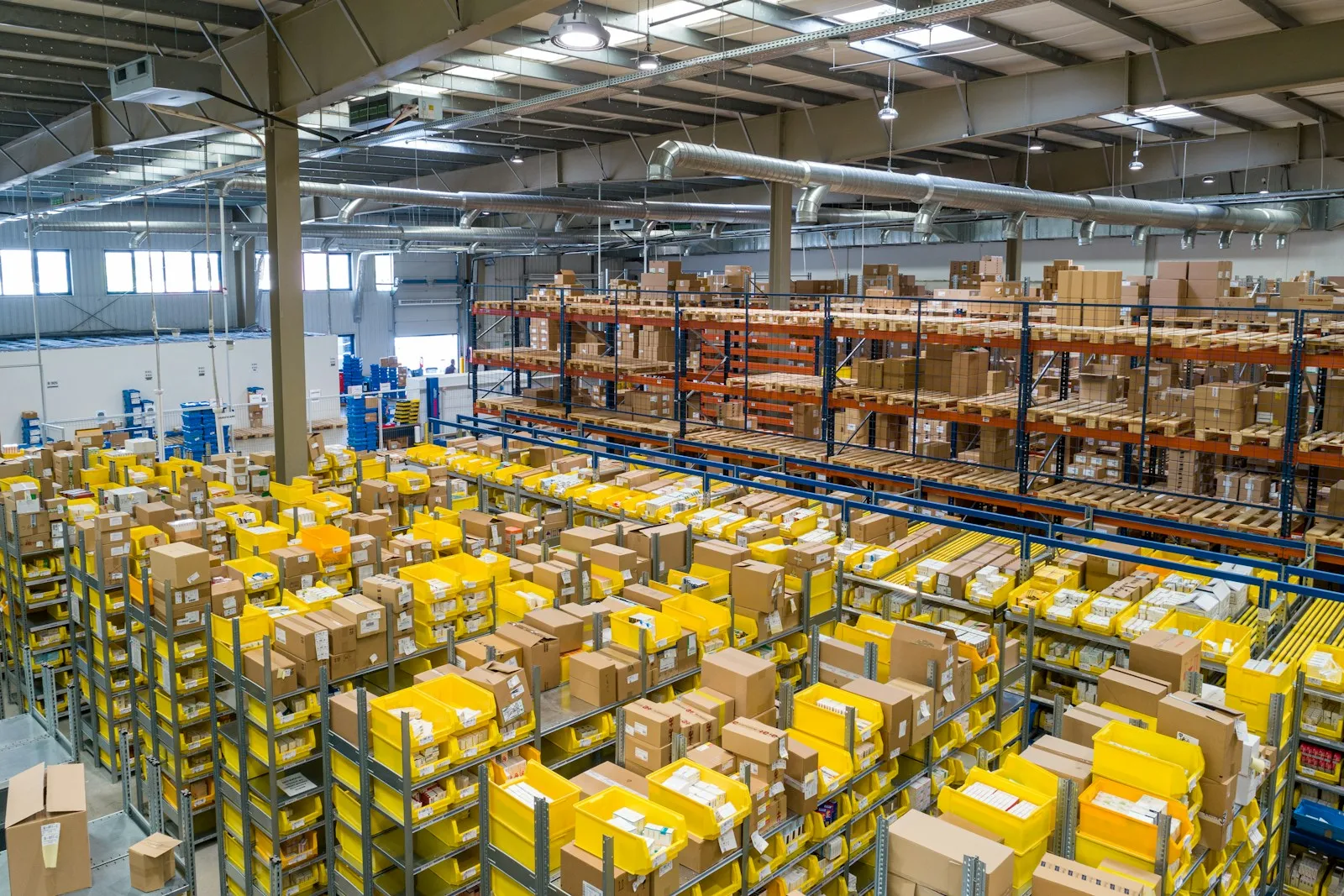 A fulfillment warehouse with pallet racking, picking bins and packed cartons